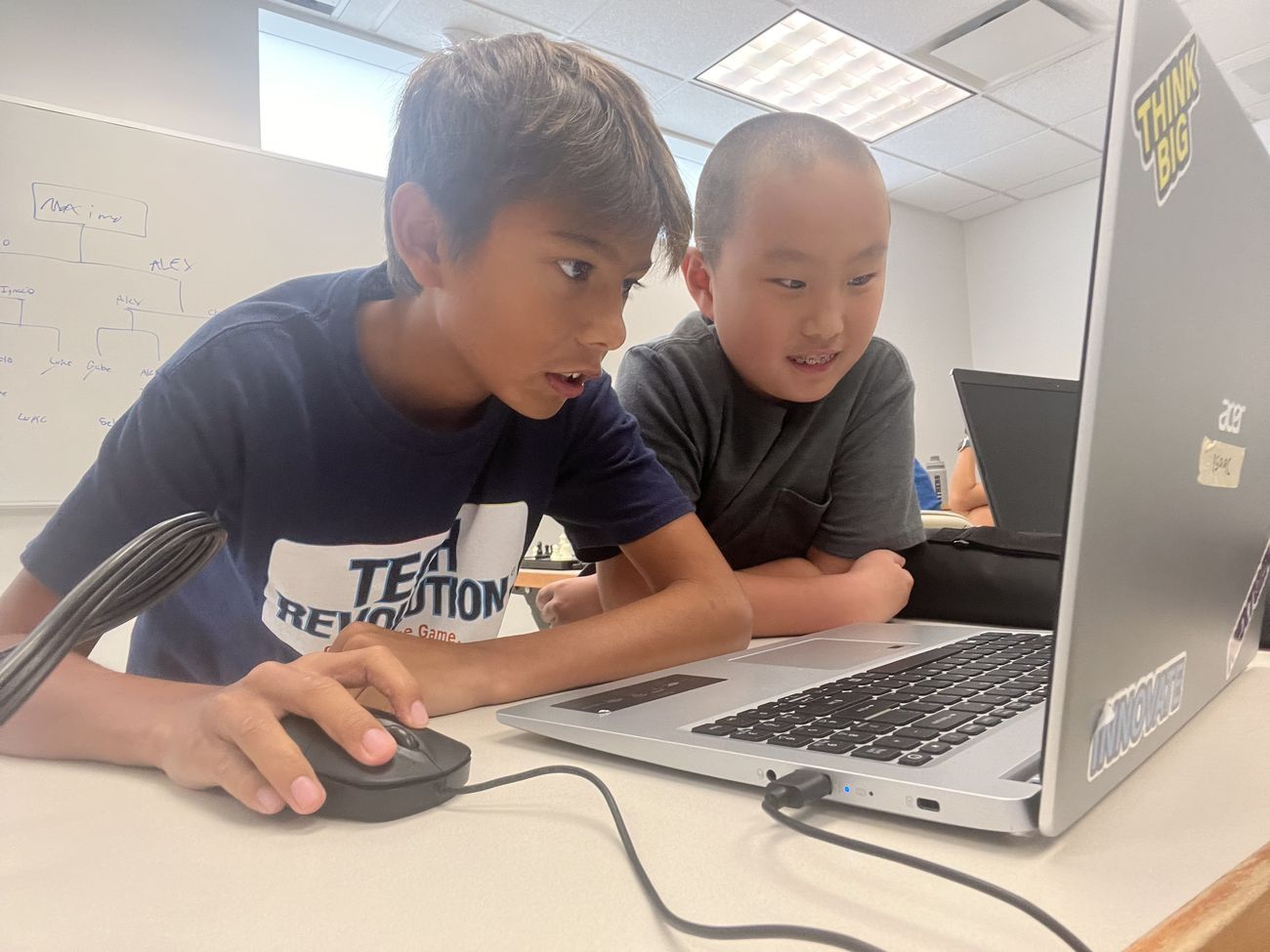 Two students working together on a laptop